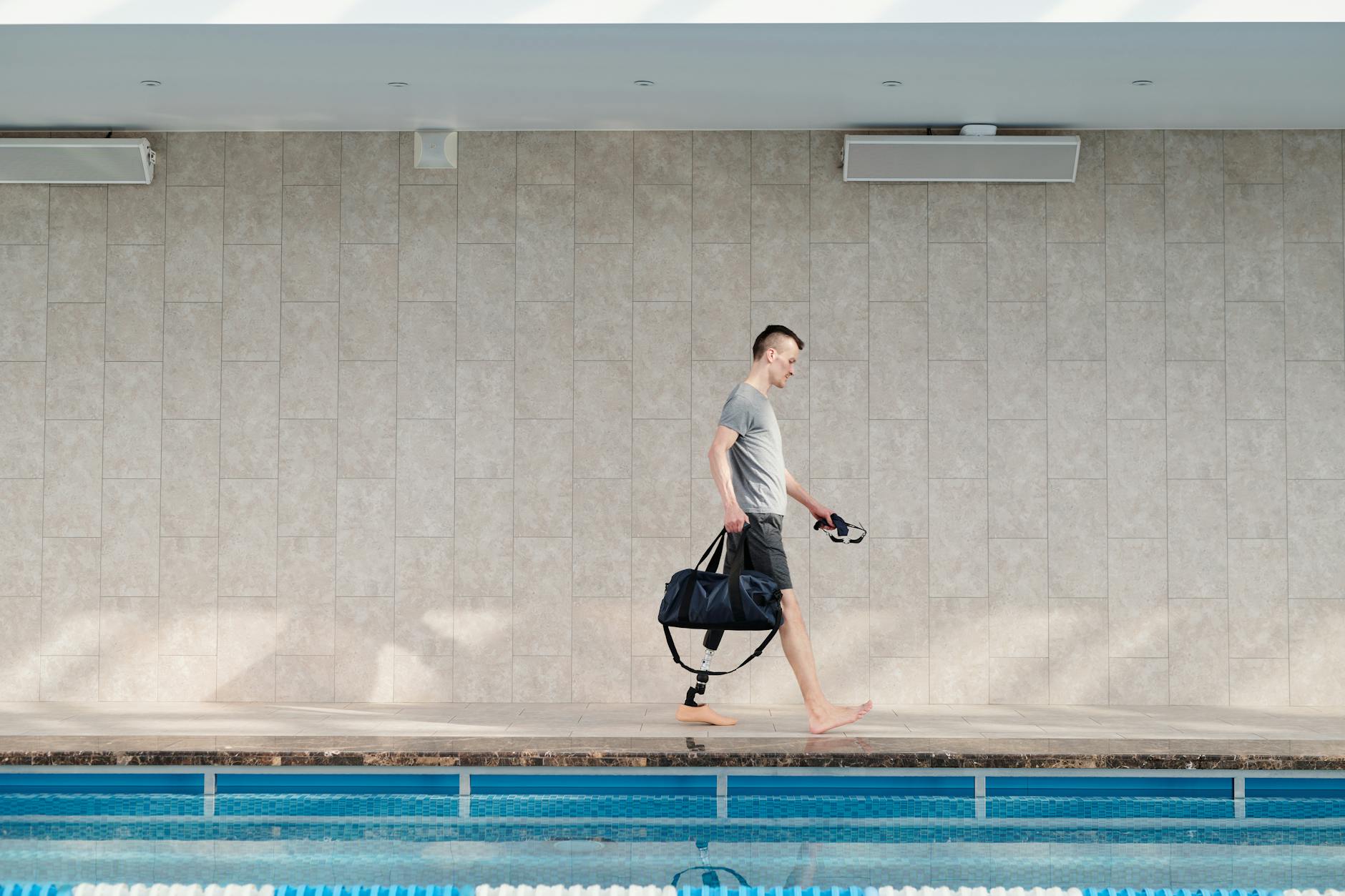 https://www.pexels.com/photo/man-with-prosthetic-leg-walking-by-swimming-pool-4047278/